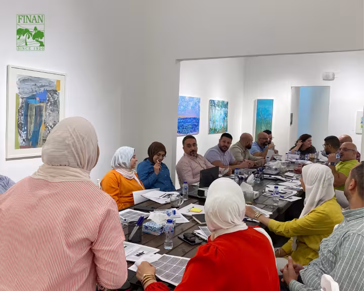 Finan team members seated around the table at the technical and business training